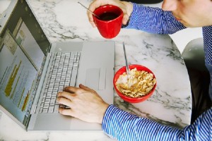 a man working at home while eating breakfast